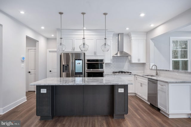 kitchen with a center island, dark wood-type flooring, wall chimney exhaust hood, a sink, and appliances with stainless steel finishes