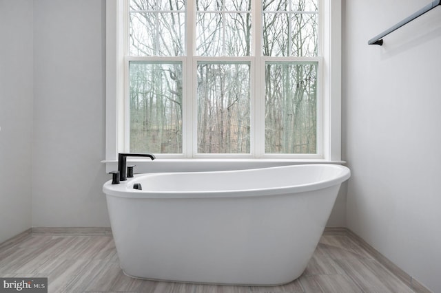 bathroom with a freestanding tub and baseboards