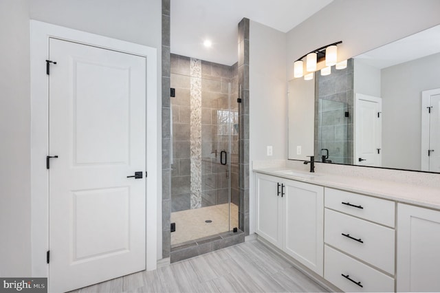full bathroom with recessed lighting, a shower stall, and vanity