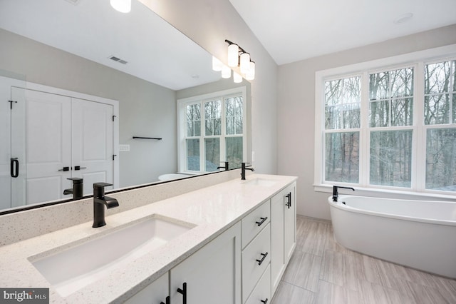 full bath with visible vents, a sink, and a healthy amount of sunlight