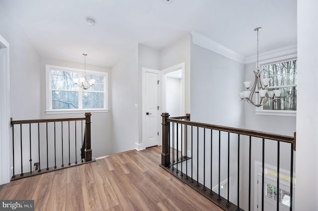 hallway with an upstairs landing, wood finished floors, and a notable chandelier