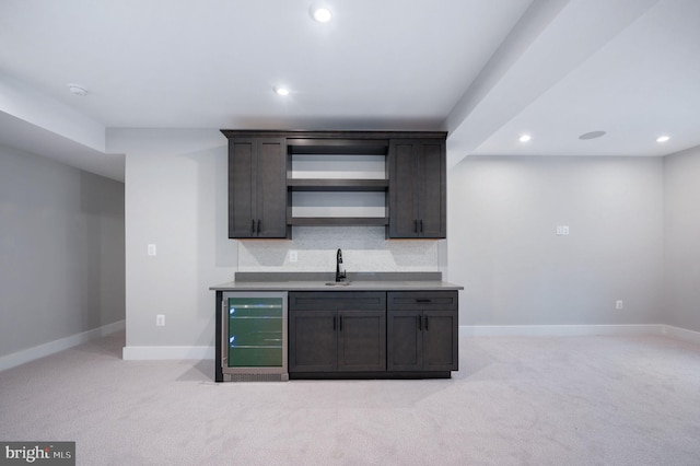 bar with beverage cooler, light colored carpet, recessed lighting, and a sink