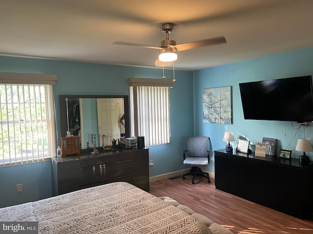 bedroom featuring baseboards, a ceiling fan, and wood finished floors