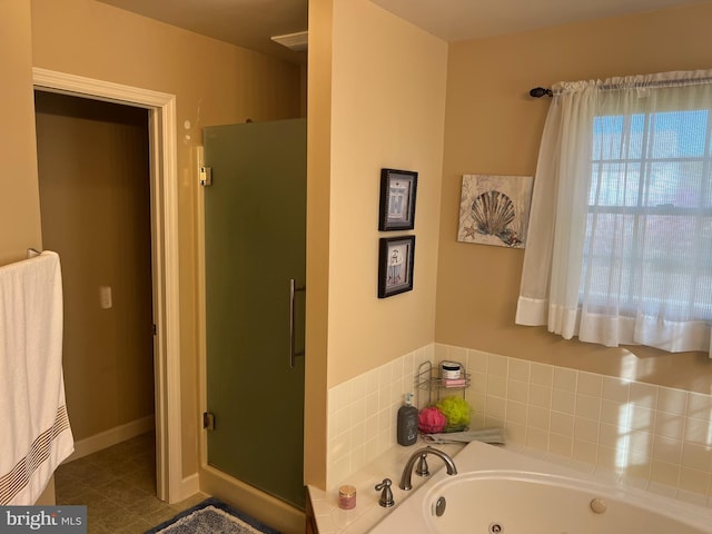 bathroom with baseboards, a whirlpool tub, and a shower stall