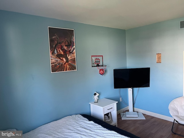 bedroom featuring baseboards, wood finished floors, and visible vents