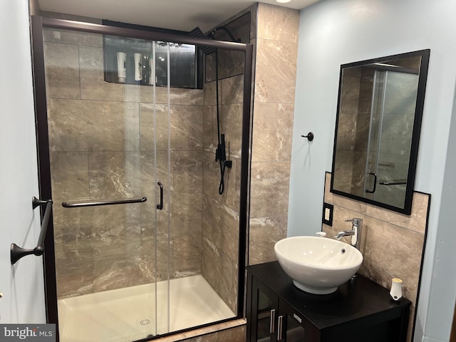 full bathroom with a shower stall, tasteful backsplash, and vanity