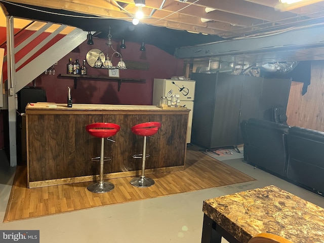 bar featuring freestanding refrigerator and bar area