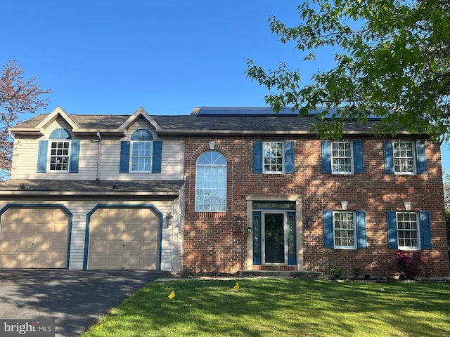 421 Coronet Dr, Blandon, PA 19510 - view of front facade with a front lawn, solar panels, an attached garage, driveway, and brick siding