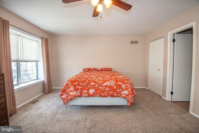 carpeted bedroom with baseboards, visible vents, and a ceiling fan