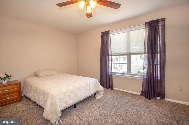 carpeted bedroom with a ceiling fan and baseboards