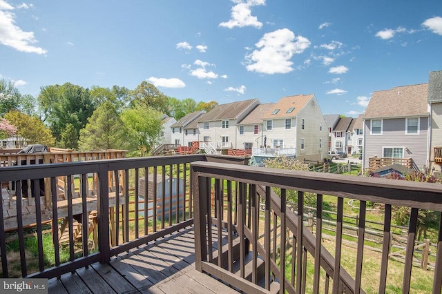 wooden terrace featuring a residential view and fence