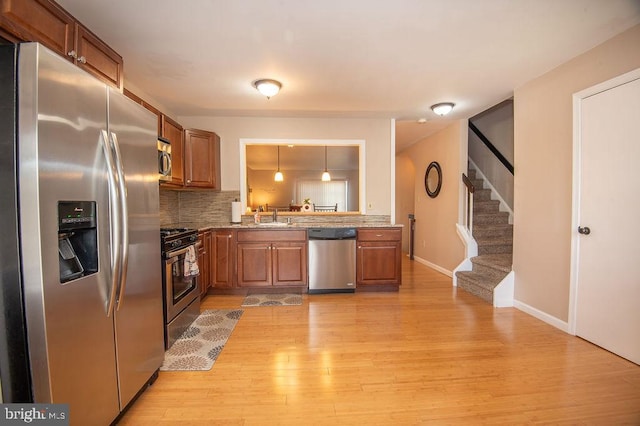 kitchen with brown cabinetry, a sink, and stainless steel appliances