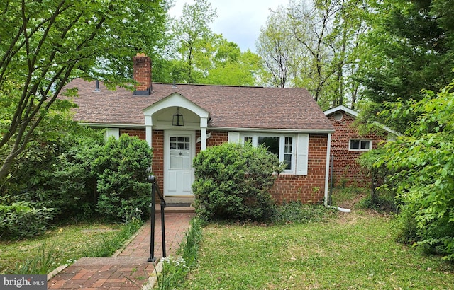 view of front of property featuring brick siding, a chimney, and roof with shingles
