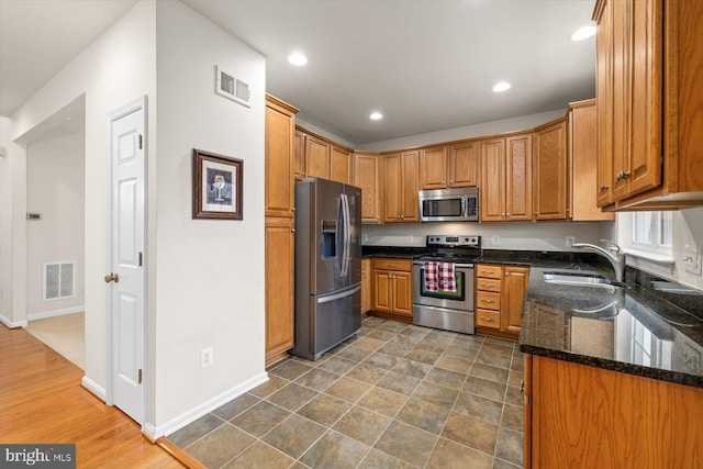 1201 Preserve Ln, Fredericksburg, VA 22401 - kitchen featuring dark stone counters, a sink, appliances with stainless steel finishes, and visible vents