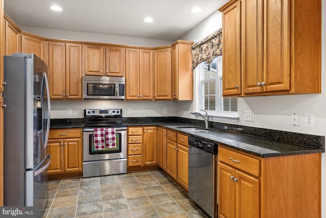 1201 Preserve Ln, Fredericksburg, VA 22401 - kitchen with dark stone counters, recessed lighting, a sink, stainless steel appliances, and brown cabinetry