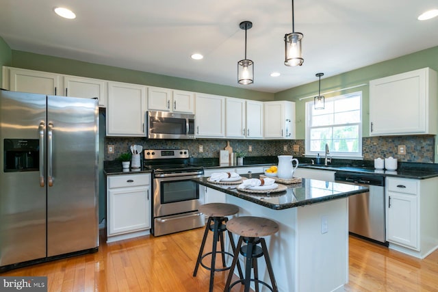 4600 Forge Acre Dr, Perry Hall, MD 21128 - kitchen featuring light wood finished floors, appliances with stainless steel finishes, white cabinets, and tasteful backsplash