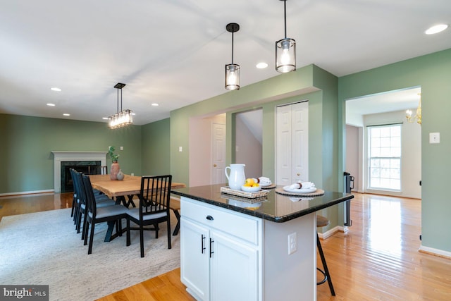 4600 Forge Acre Dr, Perry Hall, MD 21128 - kitchen featuring an inviting chandelier, light wood-style floors, a breakfast bar area, a high end fireplace, and white cabinets