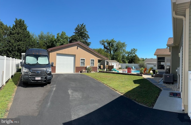 view of yard with central air condition unit, a fenced in pool, an outbuilding, and fence