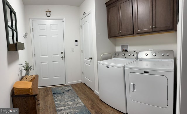 clothes washing area featuring baseboards, dark wood-style floors, cabinet space, and washer and dryer