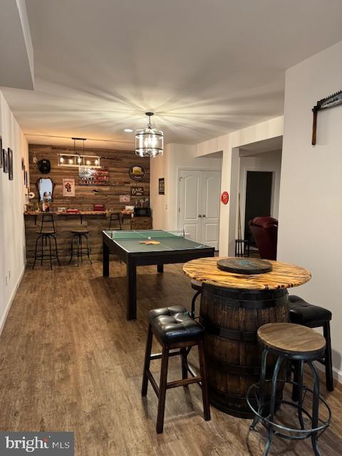 game room with pool table, baseboards, bar, and wood finished floors