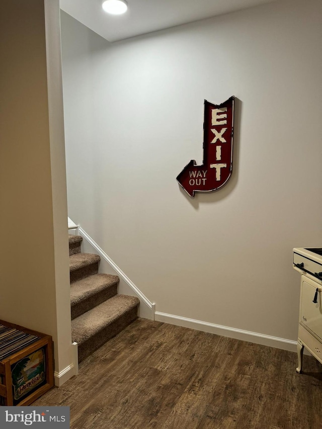 stairway featuring baseboards and wood finished floors