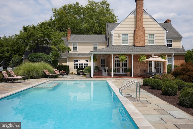 outdoor pool featuring french doors and a patio area