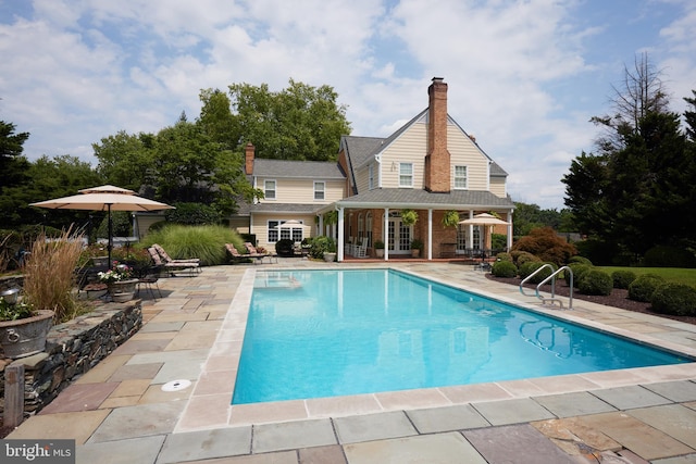 pool with a patio area and french doors
