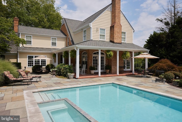 rear view of property with a patio, french doors, and a chimney