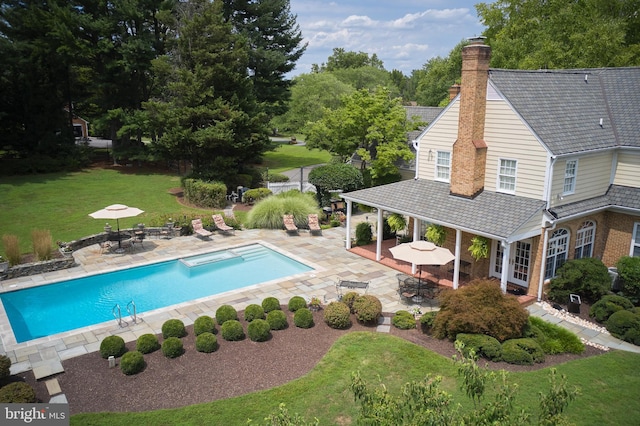 outdoor pool featuring a lawn, outdoor dining space, and a patio