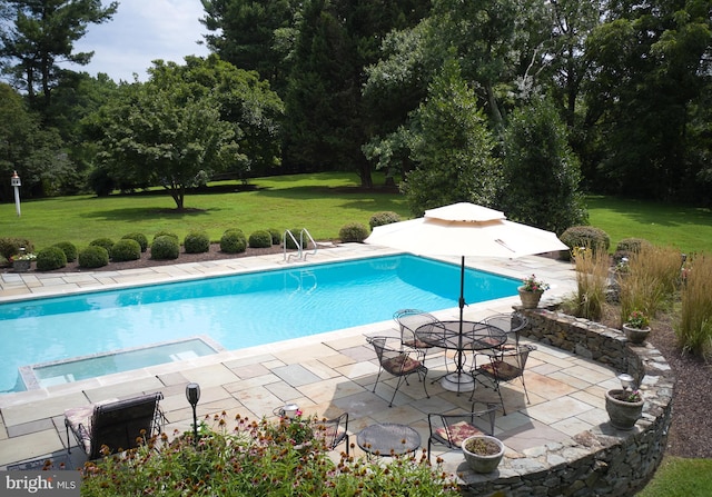 view of pool featuring a patio, a yard, and a pool with connected hot tub