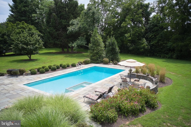 view of pool with a lawn, a pool with connected hot tub, and a patio area