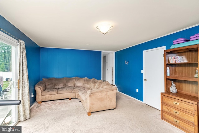 carpeted living area featuring crown molding and baseboards