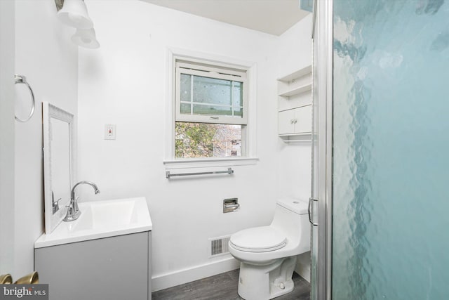 bathroom with visible vents, wood finished floors, vanity, baseboards, and toilet