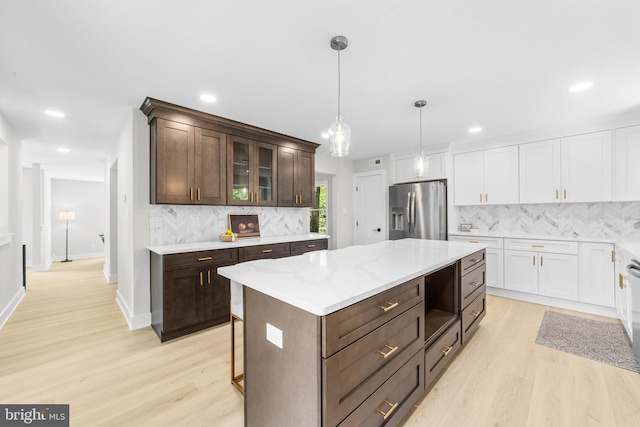 kitchen with light wood-style floors, decorative backsplash, stainless steel refrigerator with ice dispenser, and dark brown cabinets