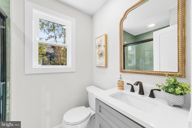 full bathroom with vanity, toilet, and tiled shower