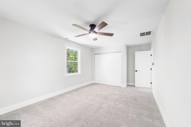 unfurnished bedroom with baseboards, visible vents, carpet, and a closet