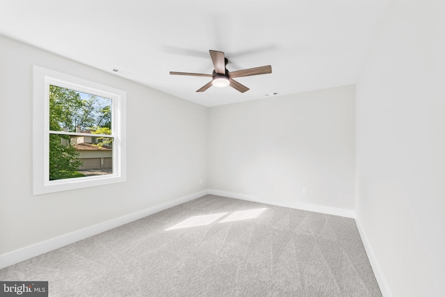 empty room featuring baseboards, carpet flooring, ceiling fan, and visible vents