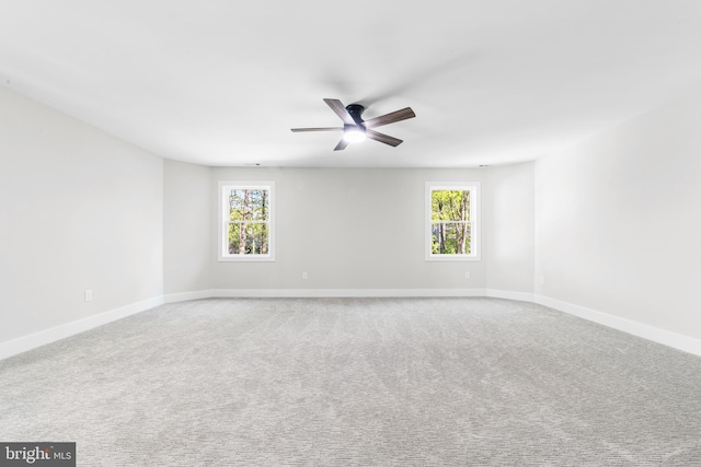unfurnished room featuring baseboards, a ceiling fan, a healthy amount of sunlight, and carpet flooring