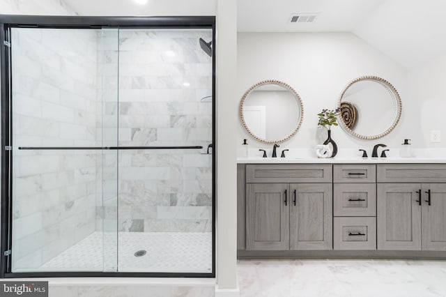 full bath with visible vents, marble finish floor, a sink, a stall shower, and vaulted ceiling