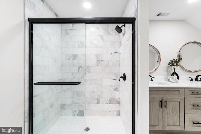 bathroom with double vanity, visible vents, and a shower stall