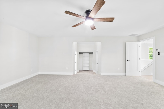 unfurnished bedroom with baseboards, light carpet, ceiling fan, and a closet