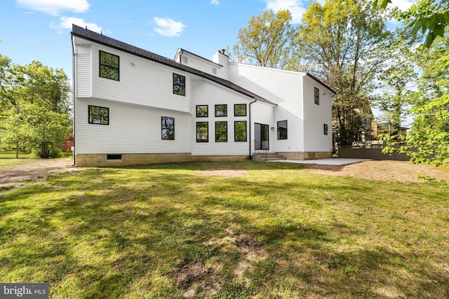 back of house featuring a lawn, fence, and a chimney