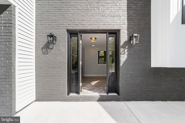 entrance to property featuring brick siding