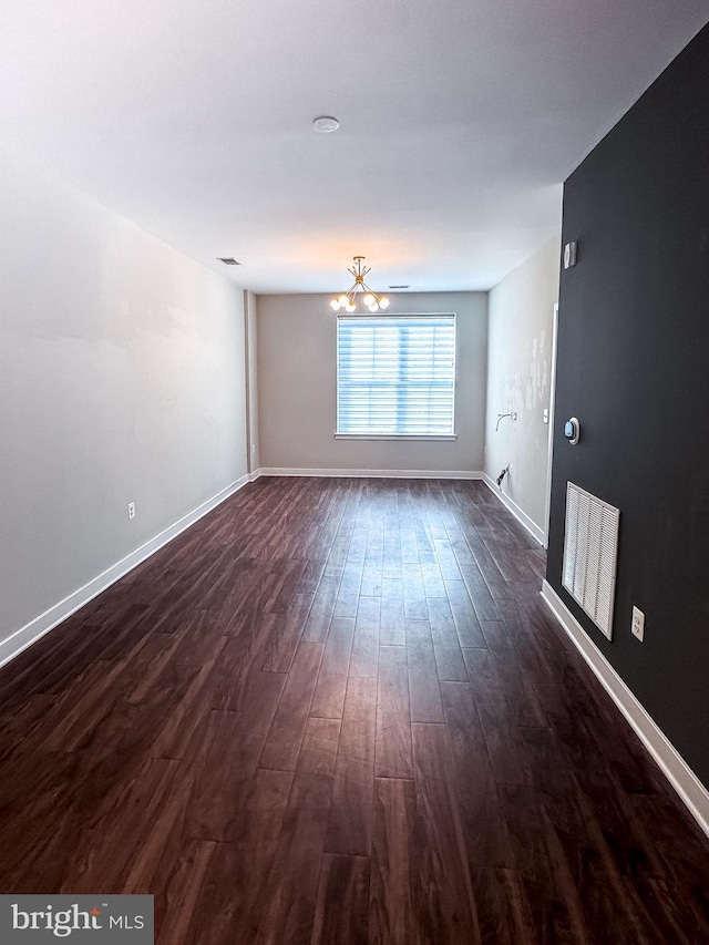 989 S Buchanan St Unit 221, Arlington, VA 22204 - unfurnished living room featuring visible vents, a notable chandelier, dark wood-style floors, and baseboards