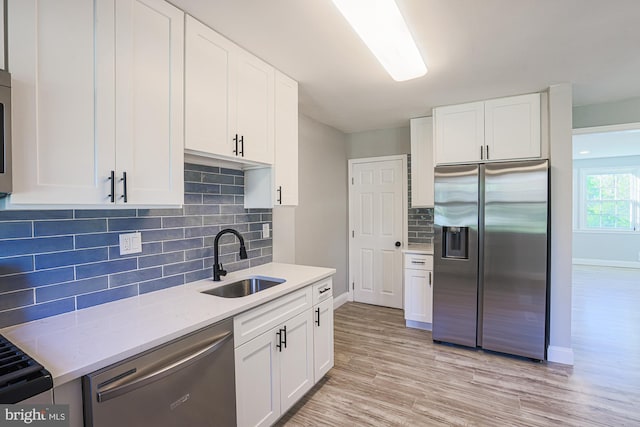 kitchen featuring a sink, stainless steel appliances, and white cabinetry