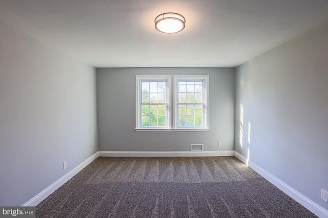 carpeted spare room featuring baseboards and visible vents