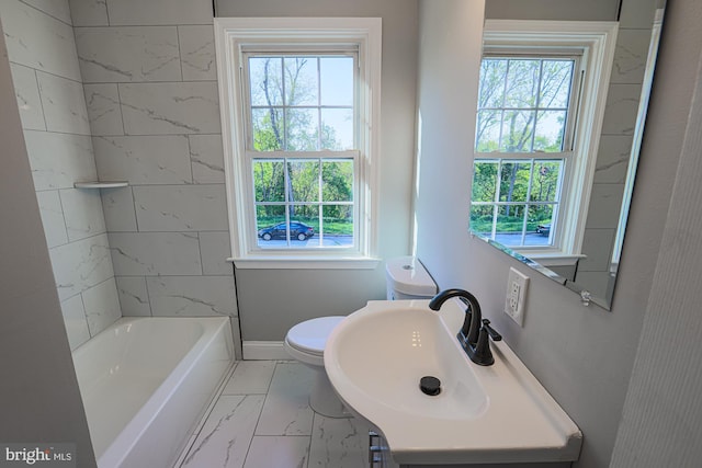 bathroom with a healthy amount of sunlight, a sink, and marble finish floor