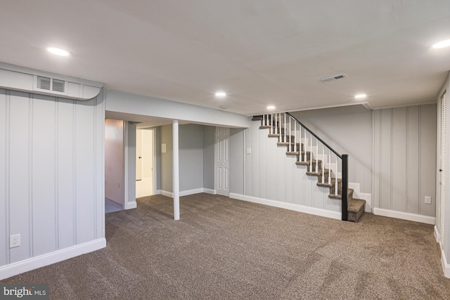 finished basement with carpet, stairs, and visible vents