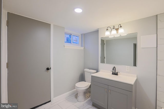 bathroom featuring vanity, marble finish floor, toilet, baseboards, and recessed lighting
