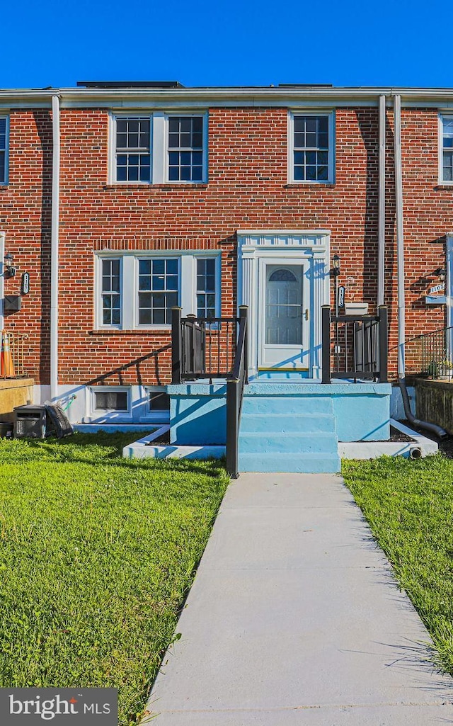 townhome / multi-family property featuring brick siding and a front yard